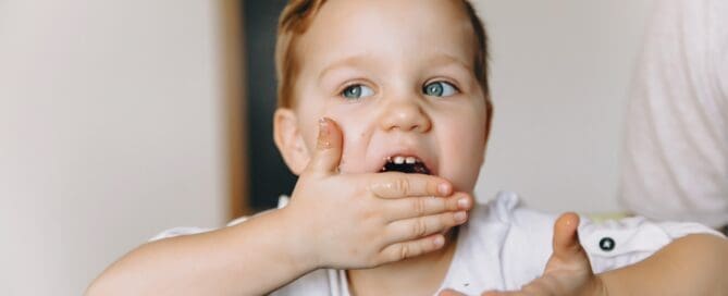 Child eating sweets impulsively from the table